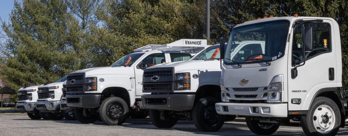 fleet of different commercial trucks in a row